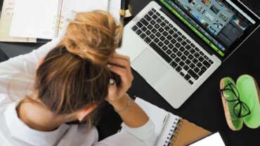 Woman at desk with head in hands, stress at work